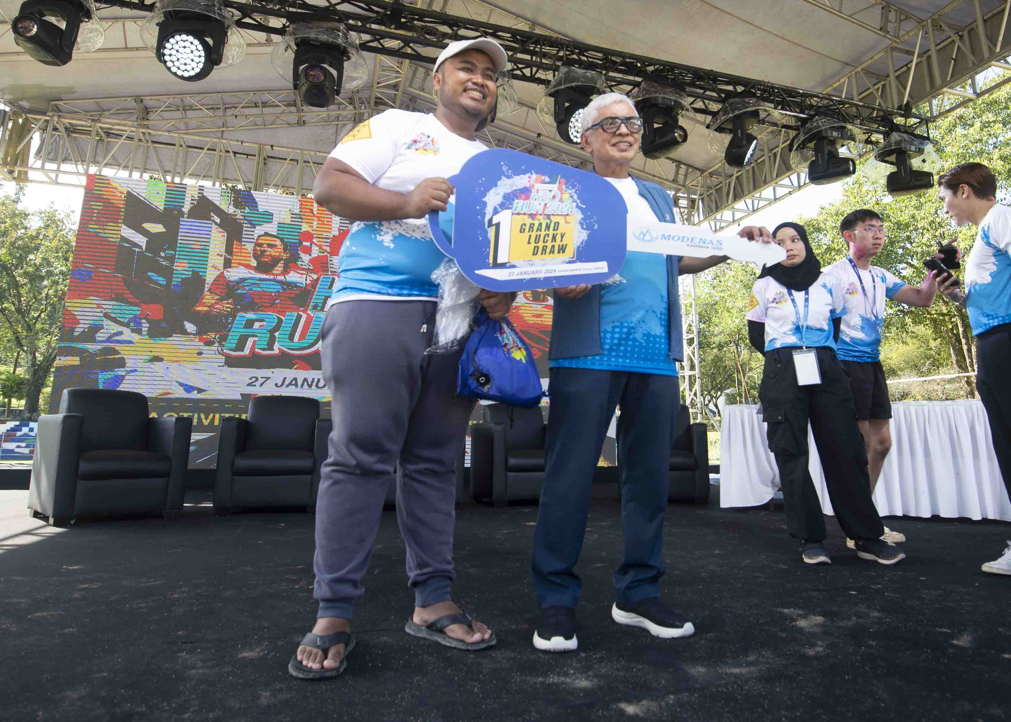 Datuk Hanifah Noordin (kanan) menyerahkan replika kunci motosikal Modenas Karisma 125 kepada Azmierul Hakkem Azmi.