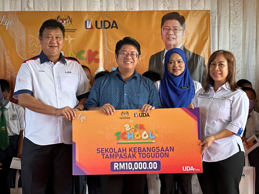 Datuk Nordin Murat (kiri) menyerahkan sumbangan untuk menambah baik tandas sekolah kepada Florencia Balagut (kanan) dan disaksikan Datuk Ewon Benedick (dua dari kiri) dan Indang Kasi Haji Sibin (dua dari kanan).