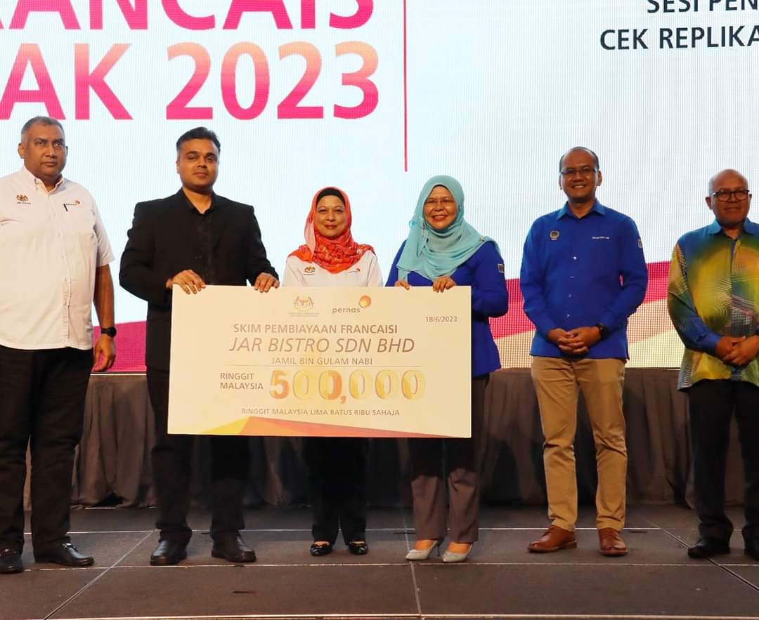 Salbiah (tiga dari kanan) bersama Hazimah (tiga dari kiri) menyampaikan replika cek pembiayaan kepada salah seorang usahawan.