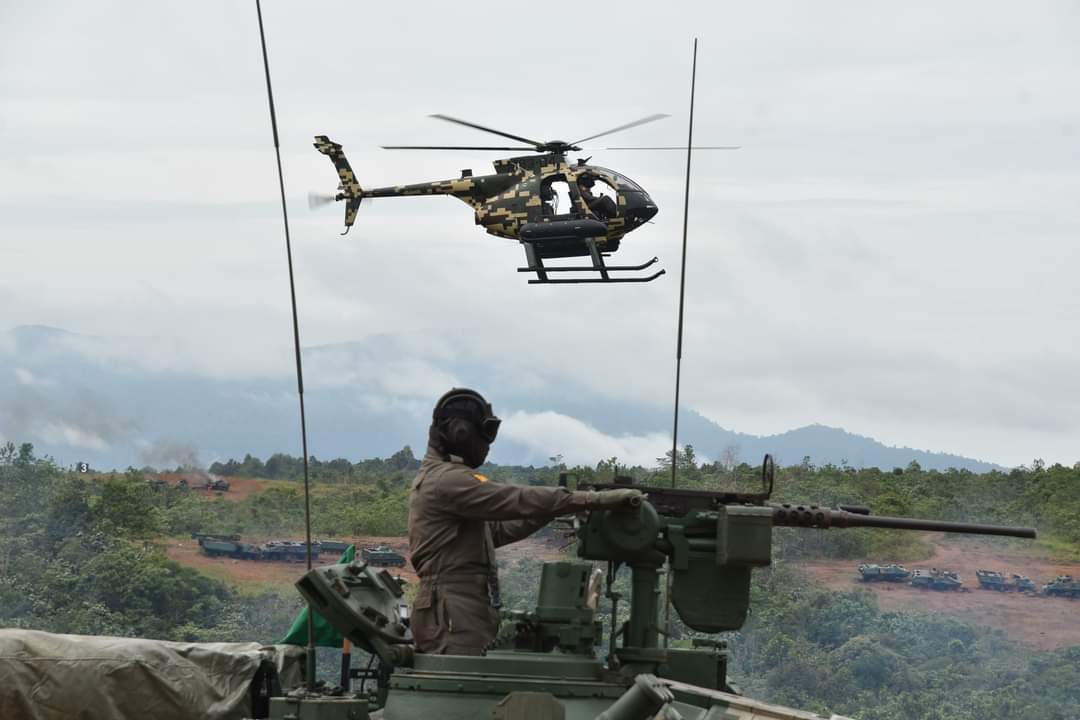 Sebuah helikopter MD530G terbang melintasi kereta kebal Pendekar.