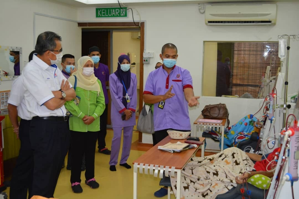 Ketua Pegawai Korporat TNB, Datuk Wira Roslan Ab. Rahman (kiri) mendengar penerangan tentang proses hemodialisis daripada seorang petugas perubatan ketika majlis penyerahan sebuah mesin dialisis kepada Pusat Yayasan Kebangsaan Negara (YKN) di Kota Bharu pada 28 September lalu.