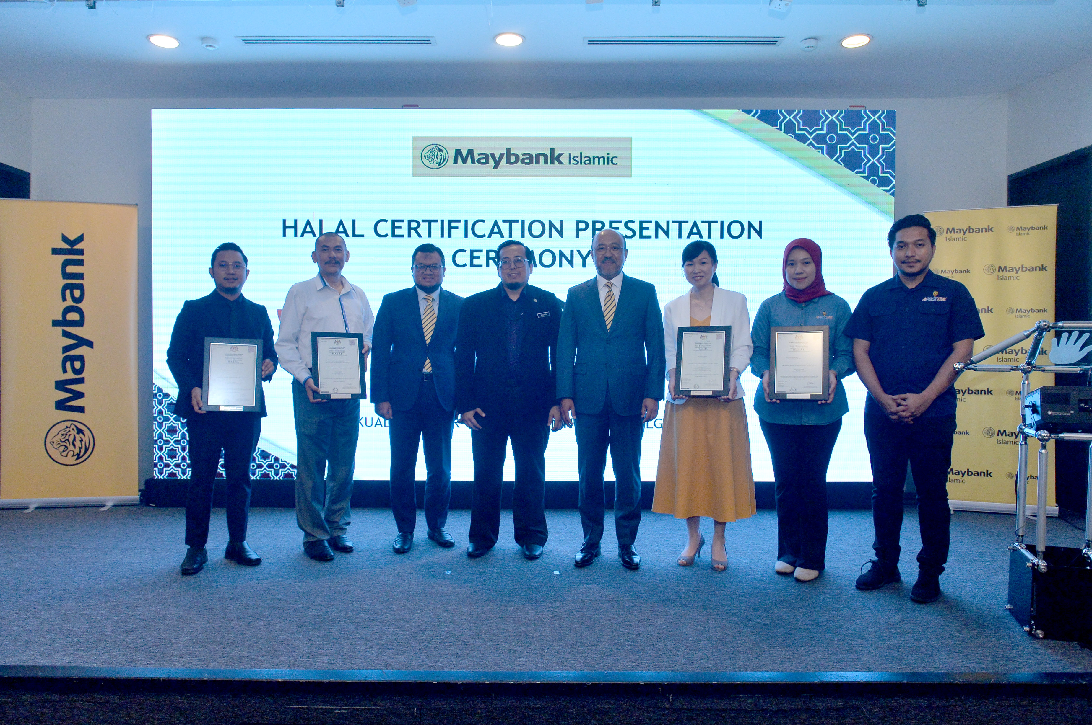 Penolong Pengarah Kanan Jabatan Kemajuan Islam Malaysia (JAKIM), Mohd Shahril Abd Samat (keempat dari kiri) dan Datuk Mohamed Rafique Merican (lima dari kiri) bersama empat wakil daripada syarikat makanan dan minuman diperakui halal di bawah Inisiatif Halal Maybank Islamic semasa majlis penyerahan sijil hala