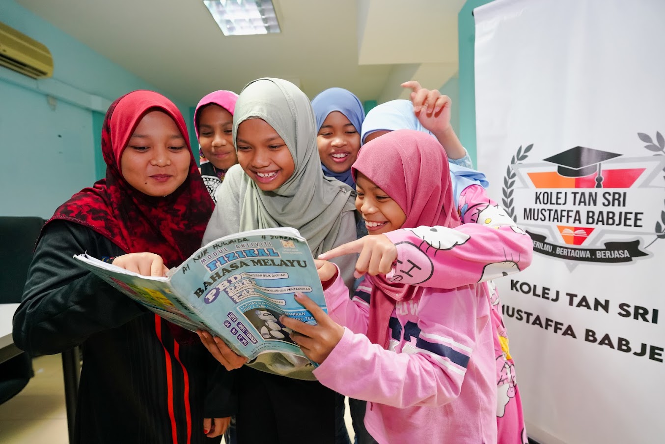 Seorang pelajar KMB UPM bersama pelajar sekolah rendah yang dibimbingnya.