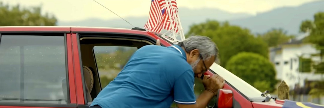 Pemandu menolak kereta Proton Saga merah
