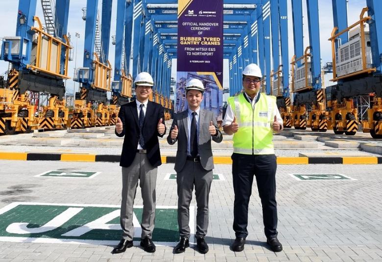 (Dari kiri ke kanan) Atsufumi Takahashi, Saito Hiroaki dan Azman Shah Mohd Yusof berdiri di hadapan kren Rubber Tyred Gantry ketika upacara penyerahan rasmi peralatan terminal baharu tersebut pada 8 Februari 2023.