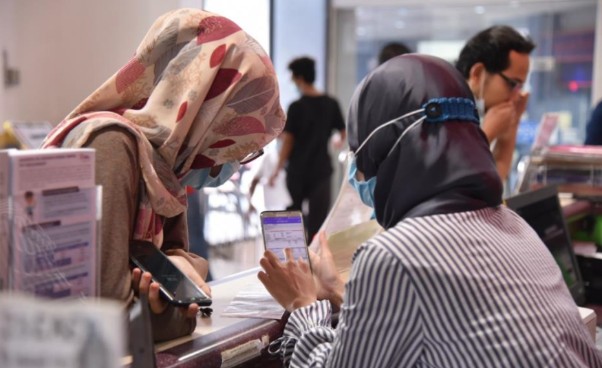 Kakitangan di TNB, menunjukkan penggunaan aplikasi myTNB kepada pelanggan. 