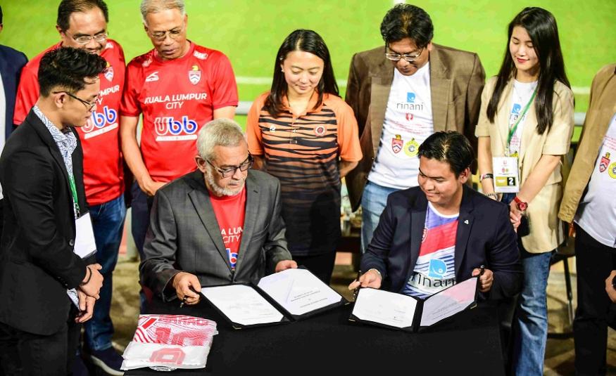 Khalid Abdul Samad (duduk kiri) dan Azri Azerai (duduk kanan) bertukar perjanjian, disaksikan oleh Menteri Belia dan Sukan Hannah Yeoh (tengah).