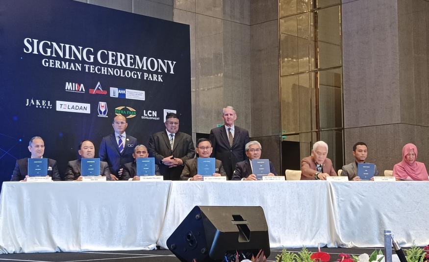 Ketua Pegawai Eksekutif Melaka Corp, Datuk Mohd Yusof Abu Bakar (duduk keempat dari kiri) dan Pengarah Urusan Teladan, Richard Teo Lay Ban (duduk kedua dari kiri) telah memeterai MoU sambil disaksikan oleh Ketua Menteri Melaka, Datuk Seri Ab Rauf Yusoh (berdiri di tengah), Setiausaha Kerajaan Negeri Melaka, Datuk Wira Zaidi Johari (berdiri di sebelah kiri), serta Duta Besar Republik Persekutuan Jerman, Dr. Peter Blomeyer (berdiri di sebelah kanan).
