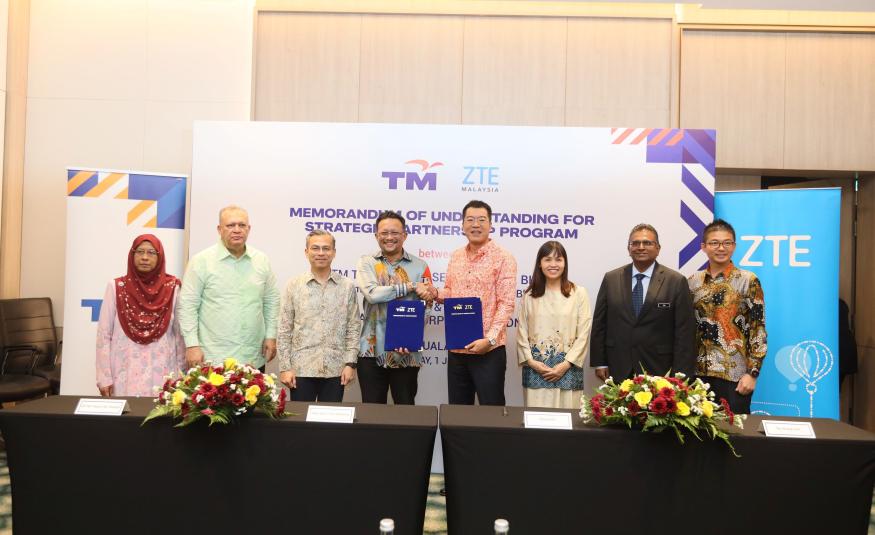 Datuk Imri Mokhtar (empat dari kiri) dan Steven Ge (empat dari kanan) bertukar dokumen MoU, disaksikan oleh Menteri Komunikasi dan Digital, Fahmi Fadzil (tiga dari kiri); Timbalan Menteri Komunikasi dan Digital, Teo Nie Ching (tiga dari kanan); Pengerusi SKMM, Tan Sri Mohamad Salim Fateh Din (dua dari kiri) dan Timbalan Ketua Setiausaha, Kementerian Komunikasi dan Digital, MA. Sivanesan Marimuthu (dua dari kanan).