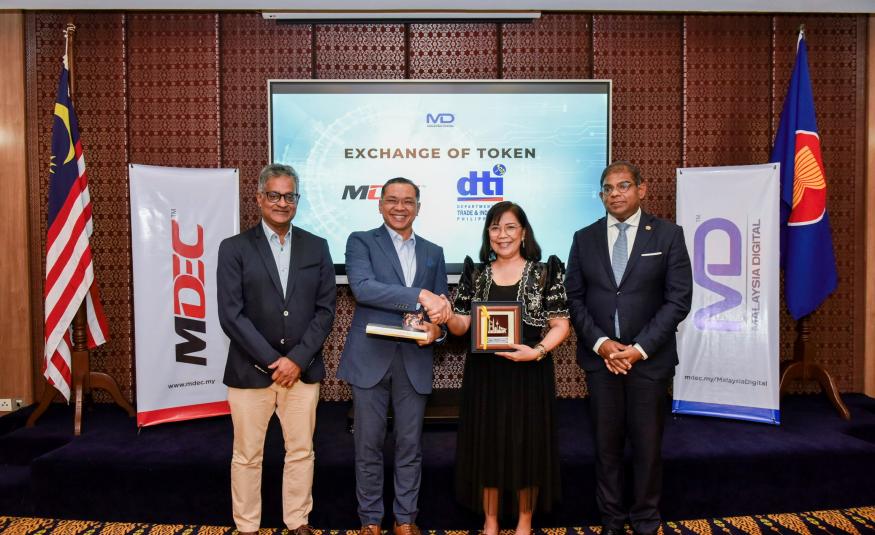 Ketua Pegawai Eksekutif MDEC, Mahadhir Aziz (dua dari kiri) bersama Penolong Setiausaha Jabatan Perdagangan dan Perindustrian (DTI) Filipina, Leny Baluyut (tengah) semasa pertukaran token di program DEX Connex Filipina di Manila.